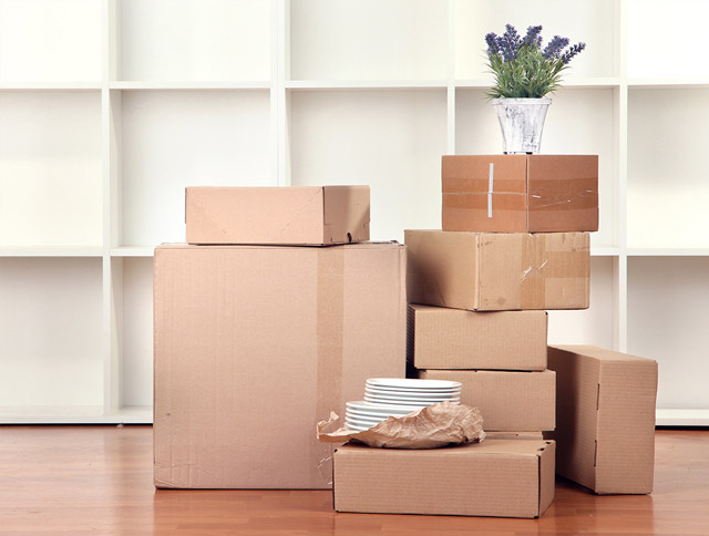 Umzugskartons vor Wohnzimmerschrank