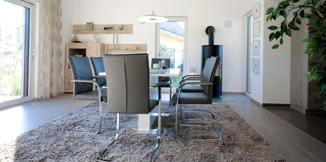 Esstischgruppe auf Teppich im sonnigen Wohnzimmer